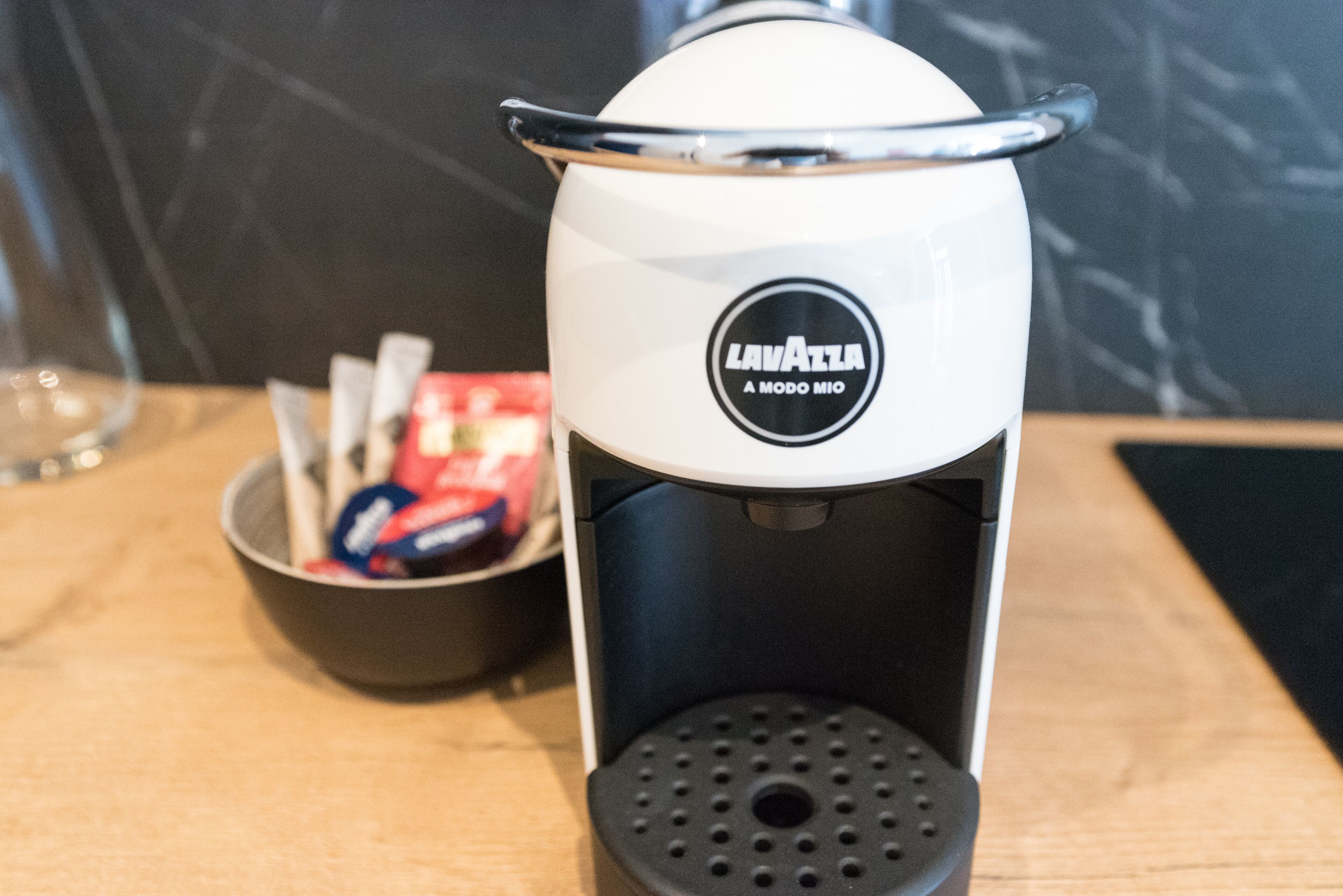 A coffee machine with a label that reads "Lavazza A Modo Mio" on a countertop.