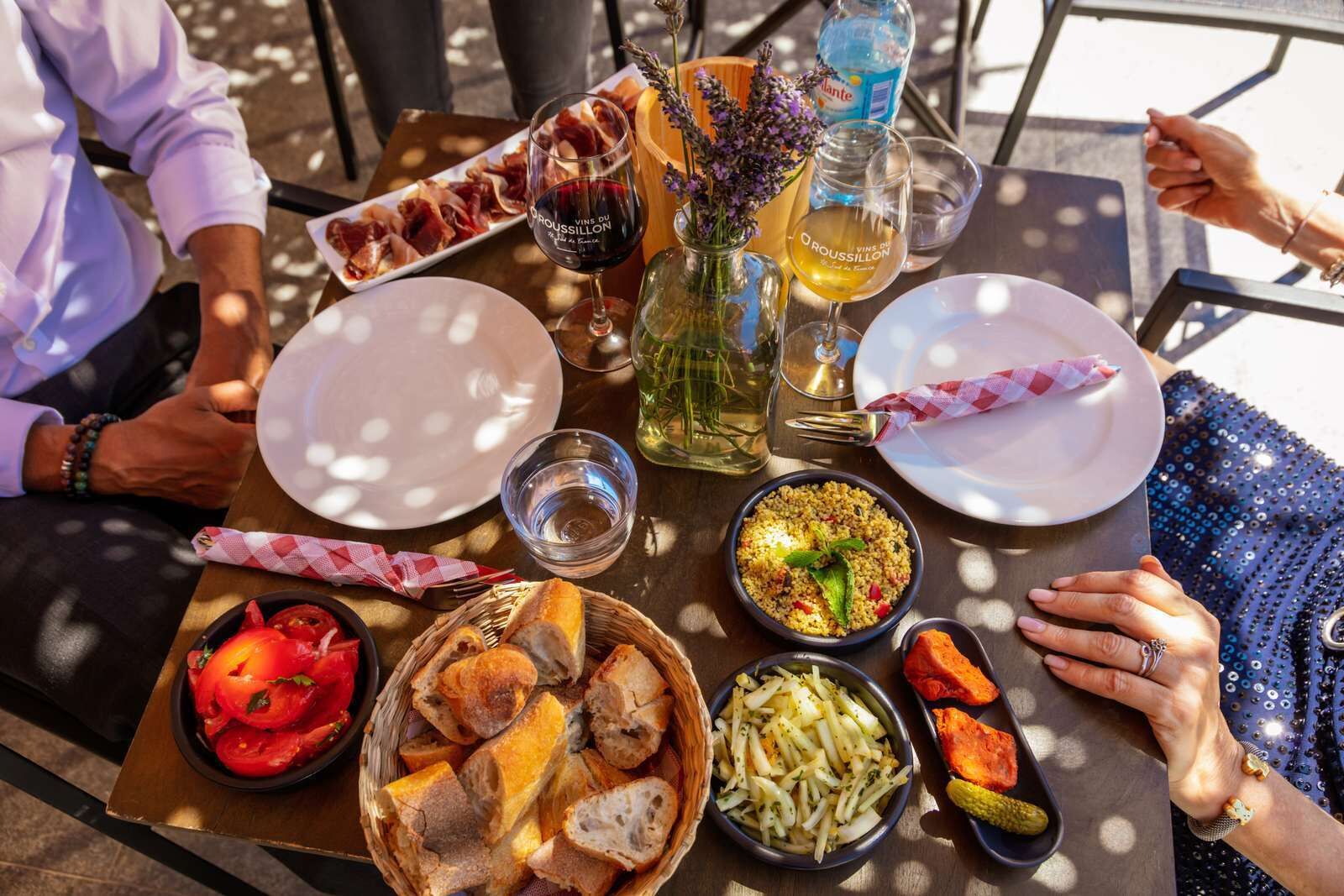 Ein Tisch ist reichhaltig mit Speisen, Getränken und einem Brotkorb gedeckt.