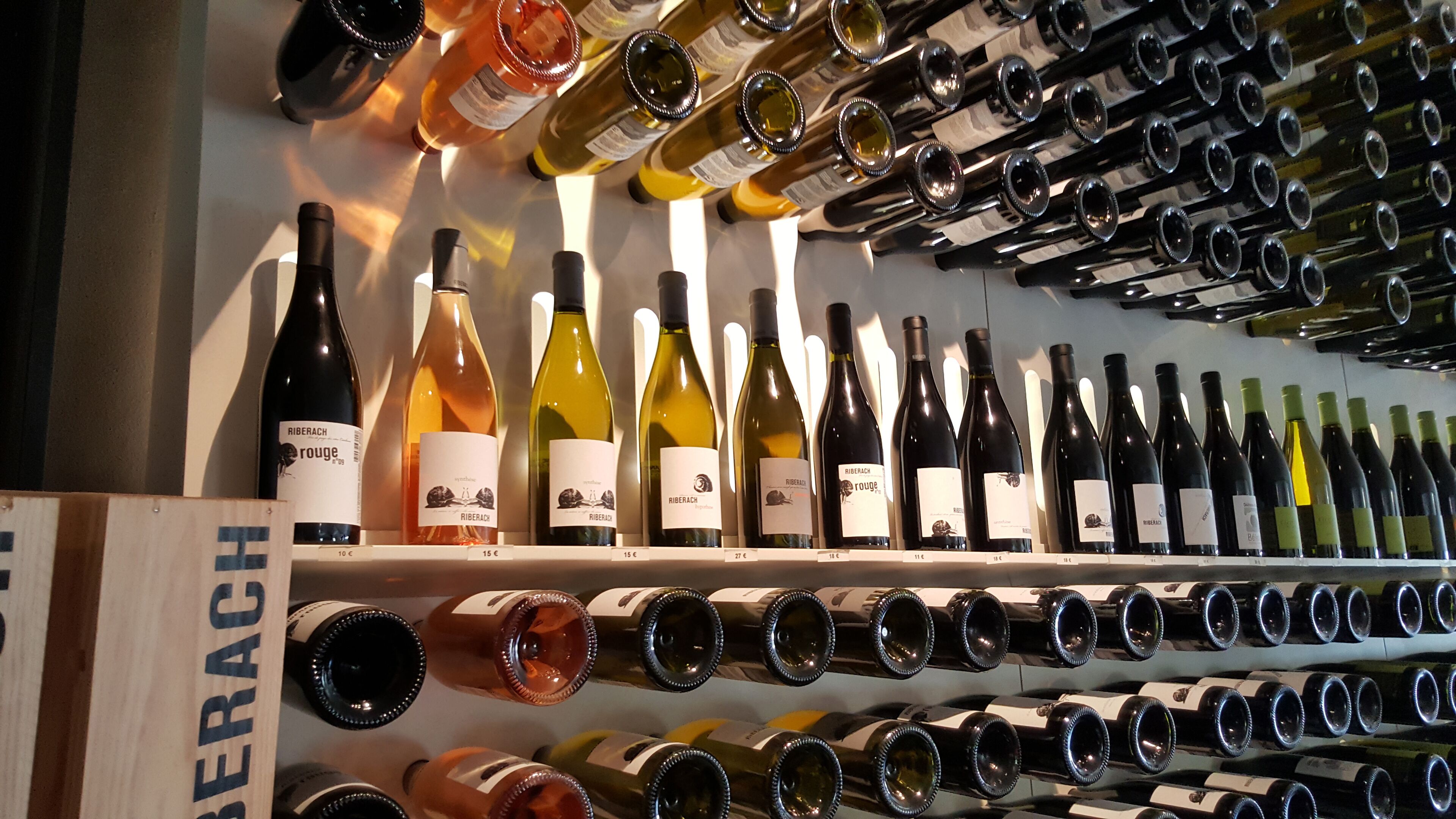 A wine rack with various bottles of wine, including red, white, and rosé.