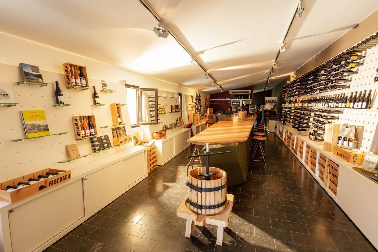 A wine shop with wooden shelves and a barrel in the center.