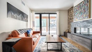 A modern living room with a sofa, coffee table, and fireplace.