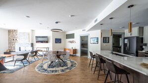 A modern kitchen with a white countertop, stainless steel appliances, and pendant lighting.