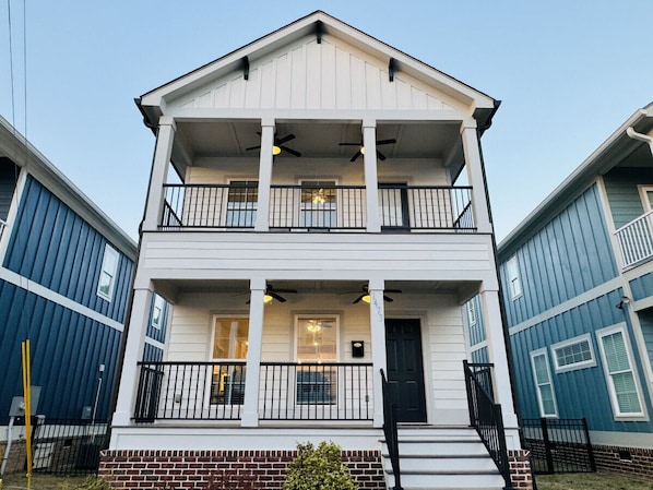 A two-story building with a balcony on the upper floor and a front door with a small porch.