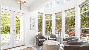 A spacious room with large windows, a round coffee table, and two armchairs. - 1 Minute Stroll to Gulf with Private Heated Pool, Bikes, and a Gulf View (Santa Rosa Beach)