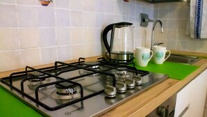 Eine Küche mit einem Gasherd, einer Kaffeemaschine und zwei Tassen mit dem Wort 'love'.