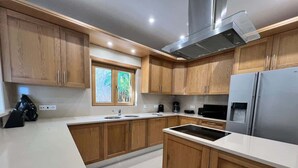 Una cucina moderna con mobili in legno, una cappa aspirante in acciaio inossidabile e un forno integrato.