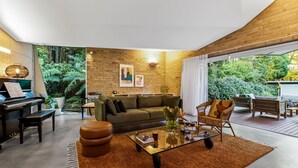 Ein modernes Wohnzimmer mit einem Klavier, einem Glastisch und einem Sofa.