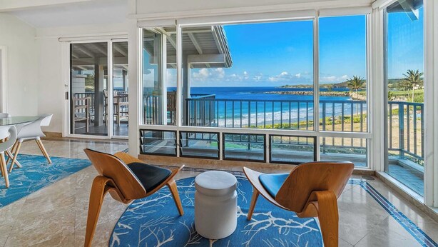 A spacious balcony with a clear view of the ocean and beach.