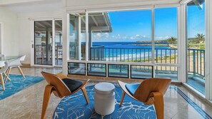 Ein geräumiger Balkon mit freiem Blick auf das Meer und den Strand.