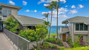 A beachfront property with multiple buildings, a clear view of the ocean, and lush greenery.