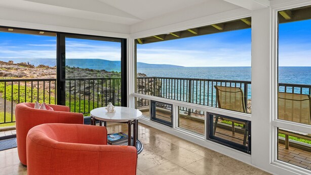 A balcony with a view of the sea, furnished with a table and chairs. - Kapalua Bay Villa 30B3 By Parrish Maui - Oceanfront panoramic views (Lahaina)