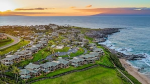 Zona residencial costera con casas de varios pisos, una carretera y una playa.