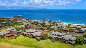 A coastal resort with multiple bungalow-style buildings, a swimming pool, and views of the ocean.
