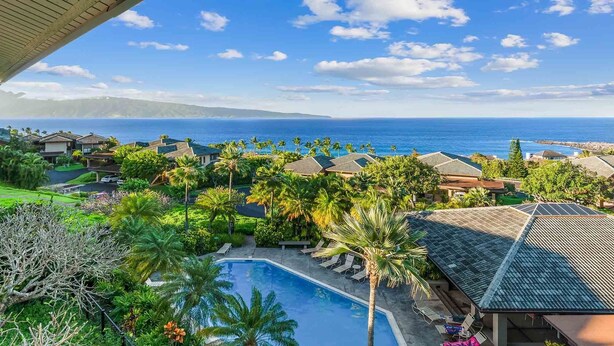 A resort with a swimming pool, palm trees, and ocean views.