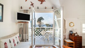 Ein Zimmer mit Bett, Fernseher, Schreibtisch und Blick ins Freie.