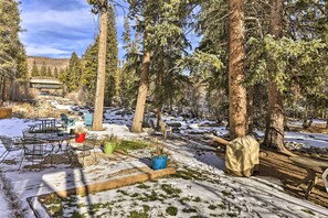 A snowy outdoor area with a dining table and chairs, surrounded by trees and a view of a building in the background. - 3 Mi to National Park: Cozy Studio in Grand Lake (Grand Lake)