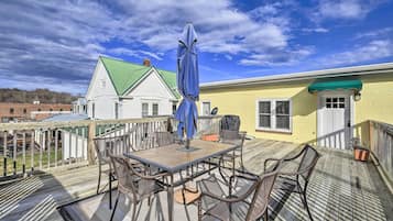 Enjoy al fresco dining on the deck with a table and chairs, shaded by an umbrella.
