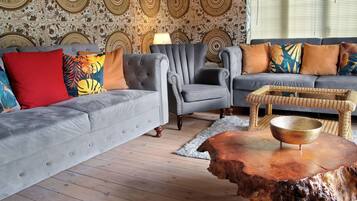 A living room with a grey sofa, a grey armchair, and a wooden coffee table with a bowl.