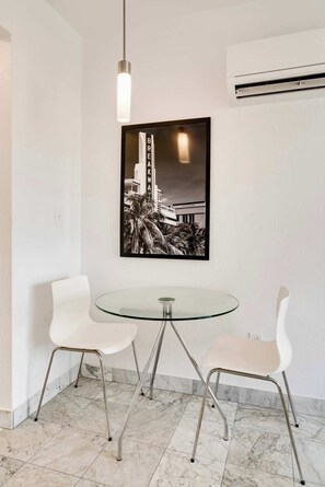 Relax in a stylish space with a round table, two chairs, and a unique black and white photograph.