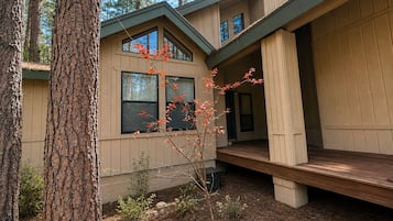 Una cabaña moderna con fachada de madera, ventanas amplias y una terraza.
