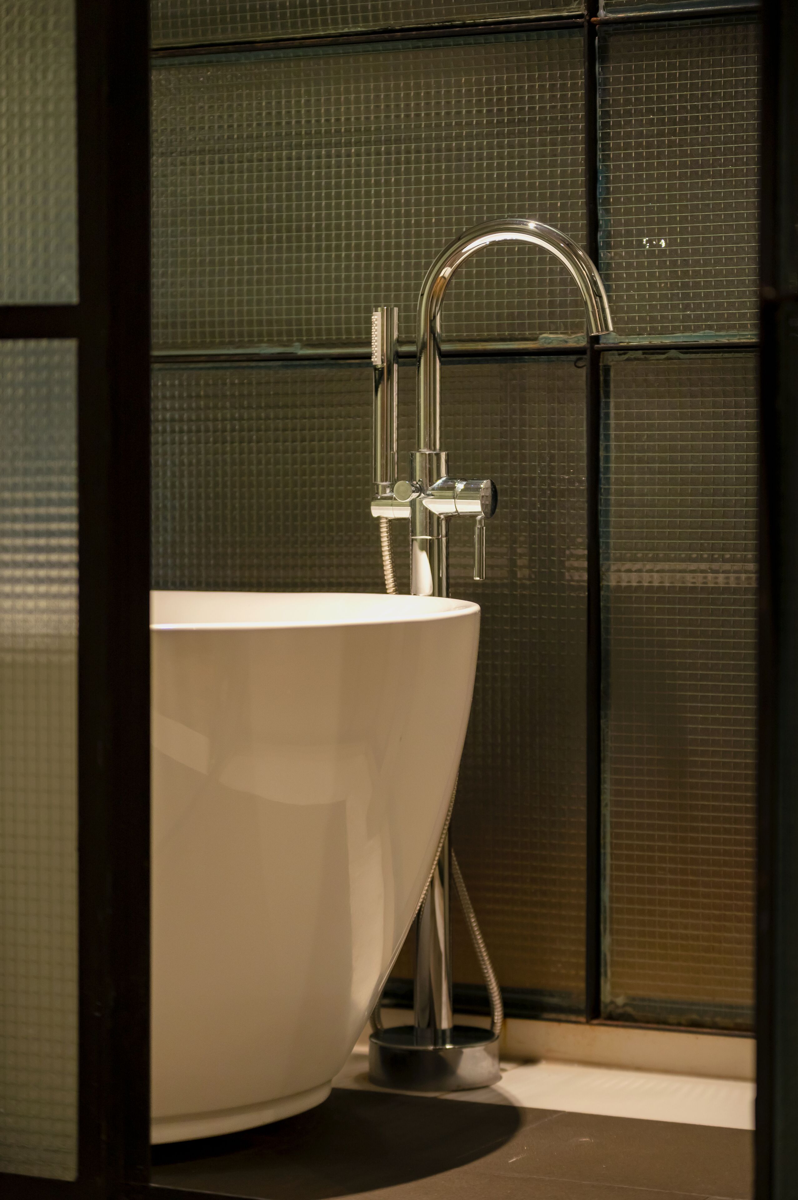 Un baño moderno con un lavabo blanco grande y un grifo cromado.