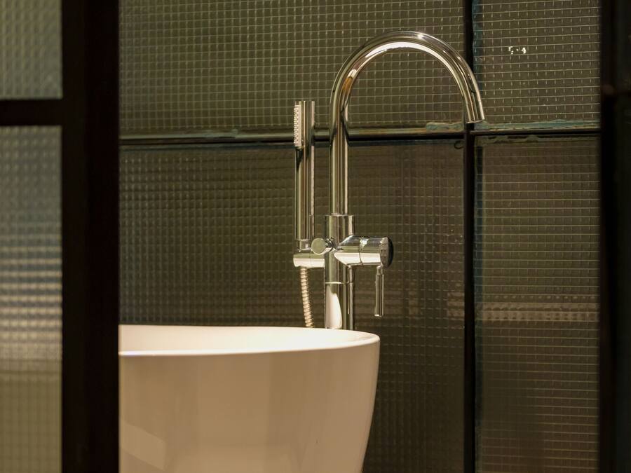 Un baño moderno con un lavabo blanco grande y un grifo cromado.