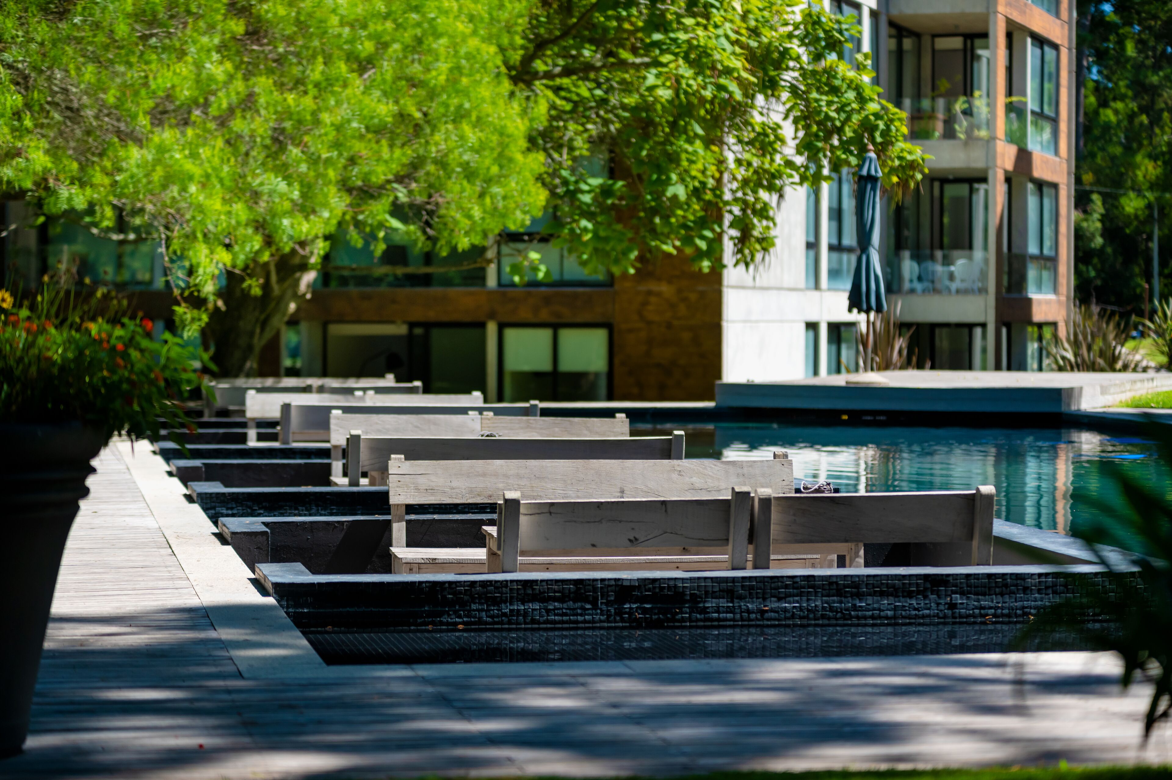 A poolside area with seating and a building in the background.