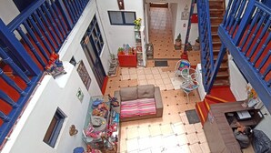 A multi-level interior with a staircase, a sofa, a small table, and various decorative items. - Kunan Cusco (Cusco)