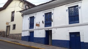 A two-story building with blue and white exterior walls, a sign reading "Kuman Hotel", and a visible entrance door. - Kunan Cusco (Cusco)