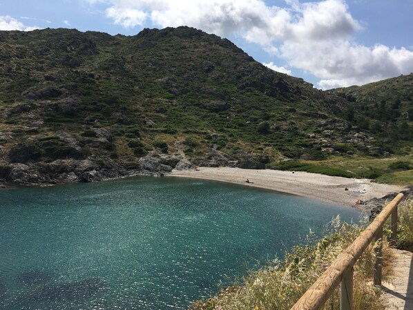 A coastal landscape with a clear blue sea, a sandy beach, and a mountainous backdrop. - New apartment, high standing, 180º panoramic view of the sea. (Llançà)