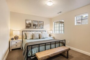 A bedroom with a bed, bedside tables, a bench, and artwork on the wall. - Angel's Landing: Pickleball, Fire Table, Games, Piano (Washtington)
