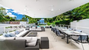 A modern outdoor patio with a pool, seating area, and dining space.