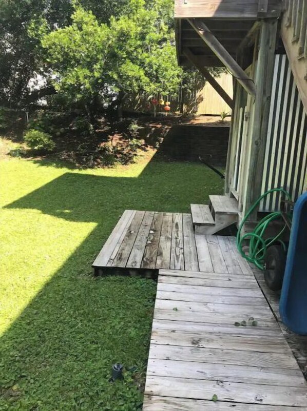 A wooden deck with a ramp leading to a house. - Emerald Mermaid cozy studio apt private beach access including parking & shower (Emerald Isle)