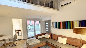 Een moderne woonkamer met een bank, salontafel en een eethoek.