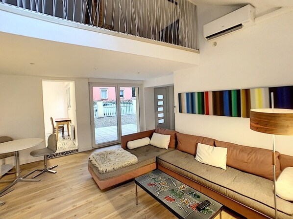 Una sala de estar moderna con sofá, mesa de centro y comedor.