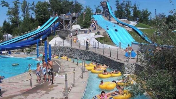 A water park with multiple slides and a pool area. - Cabin close to town, private beach, parking & hot tub (Old Forge)