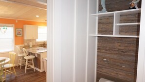 A kitchen with a wooden countertop, white cabinets, and a dining area with chairs. - Venture Out #41 Gulf Loop 2bd, 1ba WITH GOLF CART!!! (Panama City)