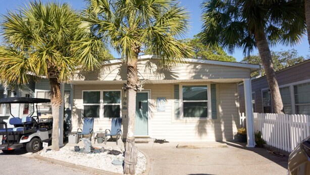 A single-story house with a front porch, palm trees, and a parked golf cart. - Venture Out #79 Gulf Loop Comes With Golf Cart!!! (Panama City)