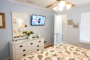 Relax in this serene bedroom with a large bed, flat-screen TV, and convenient dresser.