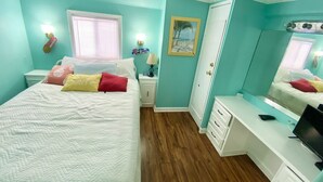 A bedroom with a bed, bedside table, nightstand, dresser, and a desk with a computer. - Venture Out, #646 Octopus Dr. Comes WITH GOLF CART! (Panama City)