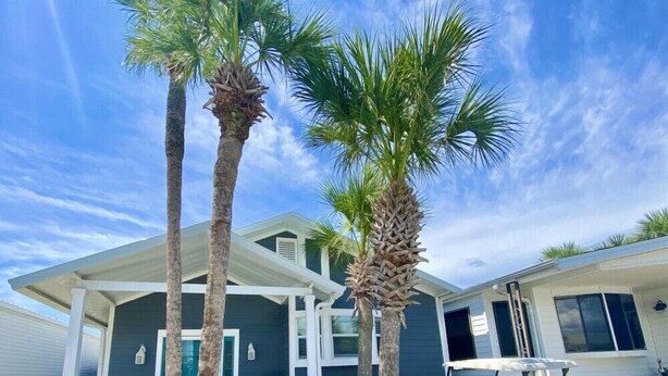 A two-story house with a covered patio, palm trees, and a golf cart. - Venture Out, #646 Octopus Dr. Comes WITH GOLF CART! (Panama City)