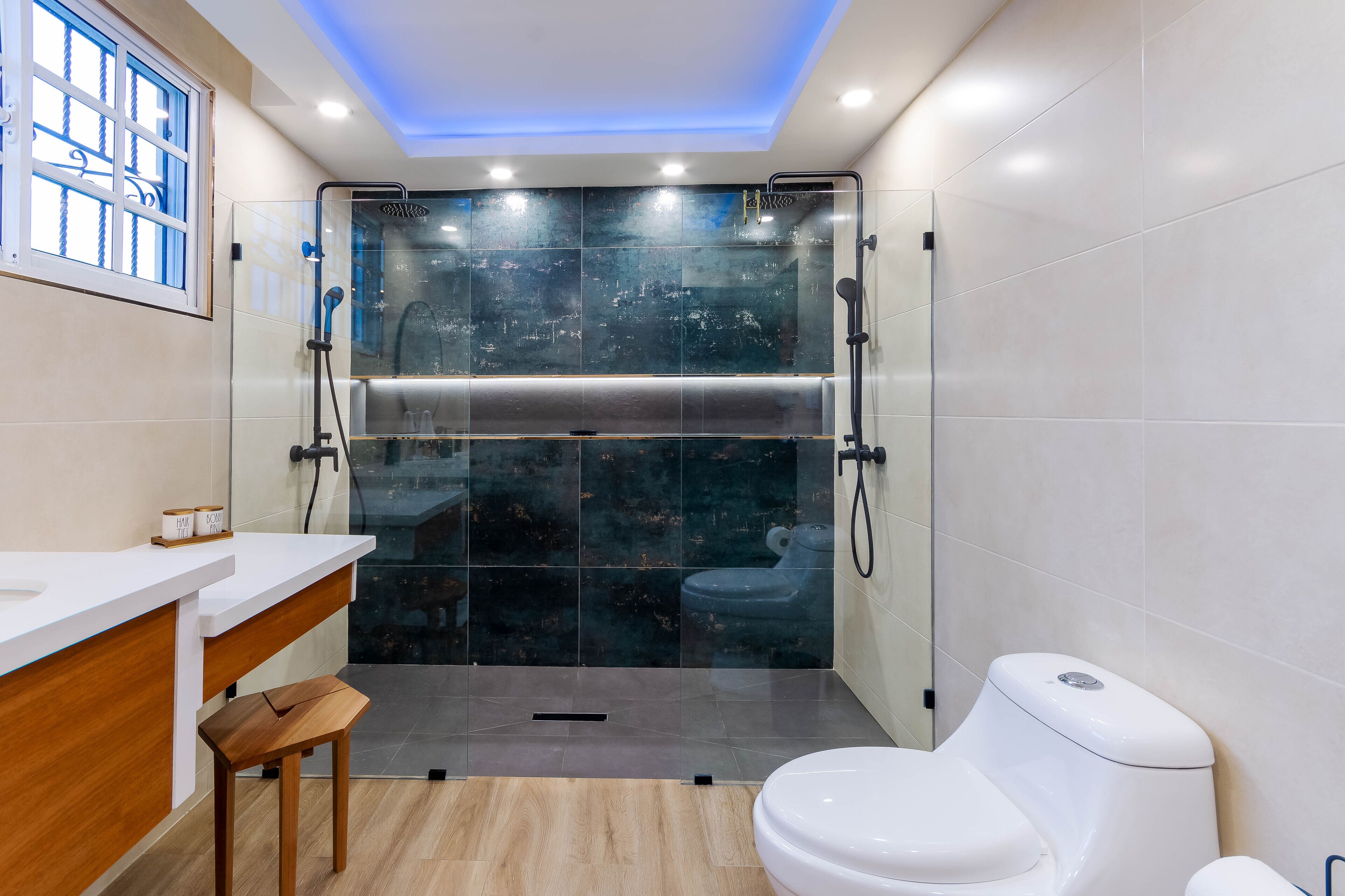 Une salle de bain moderne avec une douche à parois de verre, un meuble-lavabo en bois et des toilettes.