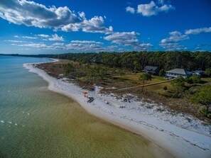 A coastal property with a beach, a large house, and a forested area. - Private Beach! Cozy Guest Cottage along Florida's Forgotten Coast. (Carrabelle)