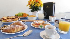 A breakfast table with croissants, toast, fruit, and a menu. - Central Plaza (Lecce)