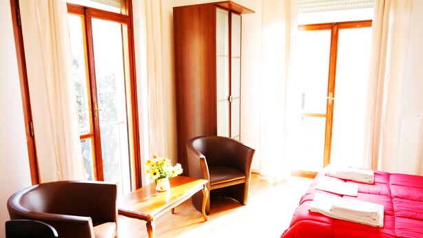 A hotel room with a bed, a desk, a chair, and a window. - Central Plaza (Lecce)