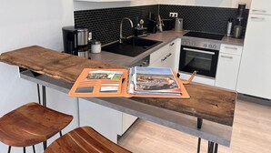 Una cocina moderna con encimera de madera, horno empotrado y salpicadero negro.