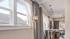 A modern dining area with a wooden table, metal chairs, and pendant lights. - Agatha Stecker cottage - Historic Miner’s cottage (Louisville)