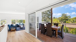 Enjoy a peaceful retreat on the balcony with a dining table and chairs, overlooking a serene landscape.