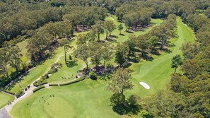 Enjoy a scenic golfing experience with well-maintained fairways, sand bunkers, and shaded tee and green areas.