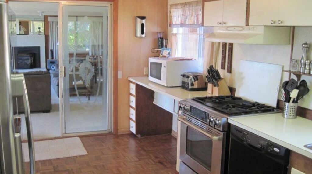 A kitchen with a microwave, stove, oven, and a coffee maker.
